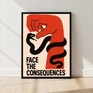 May include: Framed poster featuring a striking graphic. A red hand grips a black snake, with the words "FACE THE CONSEQUENCES" in black. The background is a light beige colour.