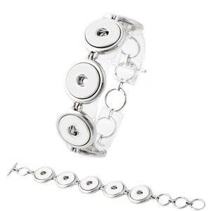 May include: A silver-toned bracelet featuring large, round, white snap-on buttons. The bracelet is composed of a series of these buttons connected by small, circular links. A second bracelet is shown below, also silver-toned, with a T-bar clasp.