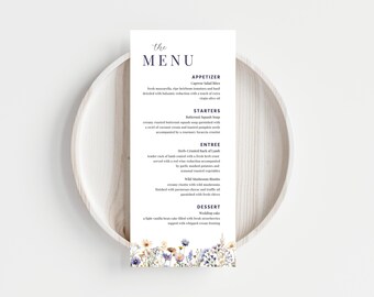 Könnte beinhalten: Eine Hochzeitskarte mit floralem Design. Das Menü umfasst Vorspeisen, Hauptgerichte und Dessert. Der Text auf der Karte lautet: "The Menu", "Appetizer", "Caprese Salad Bites", "Starters", "Butternut Squash Soup", "Entree", "Slowly roasted rack of lamb", "Dessert", "Wedding cake".