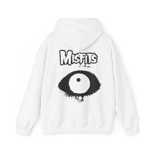 Op de afbeelding: Witte hoodie met een zwart-witte grafische print van een oog en het woord "Misfits" op de rug.