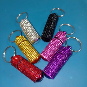 Pastillero con diamantes de imitación, organizador de pastillas portátil, llavero o colgante para bolso, 6 colores, regalo para hombres o mujeres
