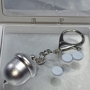Pastillero con forma de avellana, bellota, pastillero portátil, llavero o dije para bolso, plateado, sólido, impermeable y ligero.