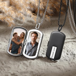 May include: Two silver-tone photo locket necklaces, one open to reveal a photo of a couple and a man, the other black with "Forever Love" text. Both pendants hang from chain necklaces, ideal for personalized gifts.
