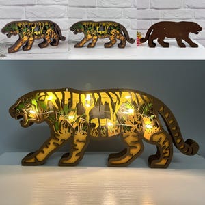 May include: A wooden tiger night light with a jungle scene and fairy lights. The tiger is brown with yellow and green accents.