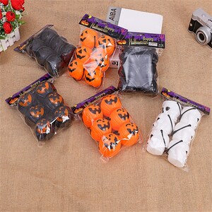 May include: A set of Halloween decorations featuring orange and black pumpkin-shaped ornaments and white ghost-shaped ornaments. The ornaments are packaged in clear plastic bags with the text "Happy Halloween" printed on them.
