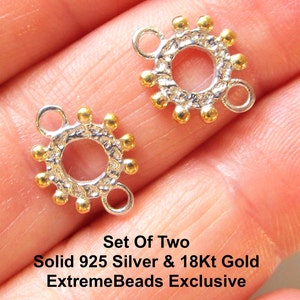 May include: Two silver and gold connector beads. Each bead has a circular design with gold accents and three loops. The text "Set Of Two Solid 925 Silver & 18Kt Gold ExtremeBeads Exclusive" is visible.