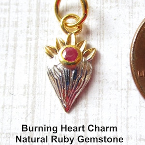May include: A silver and gold heart charm with a red ruby gemstone. The charm has a loop at the top for attaching to a necklace or bracelet.  Burning Heart Charm Natural Ruby Gemstone 925 Silver & 14K Gold ExtremebeadsExclusive