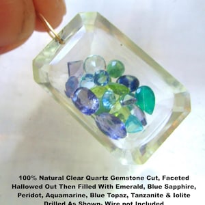 May include: A clear quartz gemstone pendant, faceted and hollowed out, filled with various gemstones including emerald, blue sapphire, and aquamarine. The pendant has a gold wire loop for hanging.