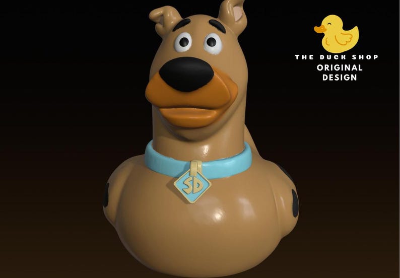 May include: A brown rubber duck shaped like a dog with a light blue collar and a diamond-shaped tag featuring the letters SD. The figure has a dark brown nose, black spots on its sides, and the text THE DUCK SHOP ORIGINAL DESIGN with a yellow duck icon.