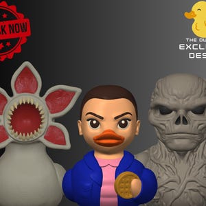 May include: Three character-themed rubber duck figures. The Demogorgon duck has a red and white flower-like head with sharp teeth. Eleven duck wears a blue jacket and holds a waffle. The Vecna duck is gray.