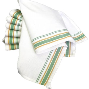 May include: A stack of white kitchen towels with green and gold stripes. The towels are folded and arranged in a pile.