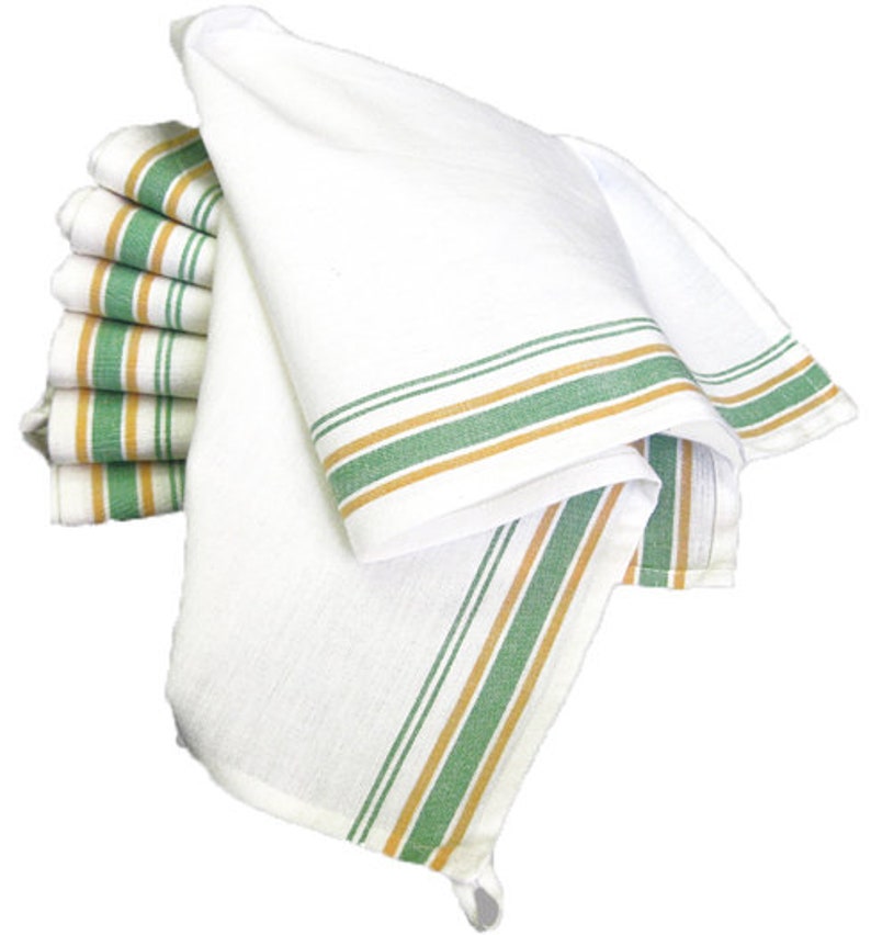 May include: A stack of white kitchen towels with green and gold stripes. The towels are folded and arranged in a pile.