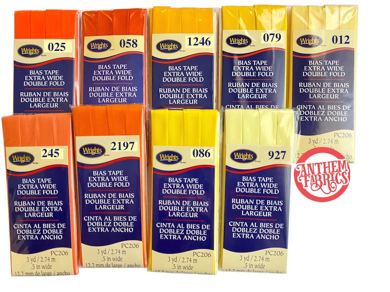 May include: Assortment of 10 rolls of extra wide double fold bias tape in orange and yellow colors. Each roll is labeled with the brand name "Wrights" and a product number. The tape is 5 inches wide and 3 yards long.