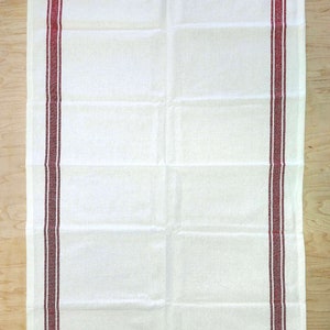 May include: White kitchen towel with two red stripes along the sides.