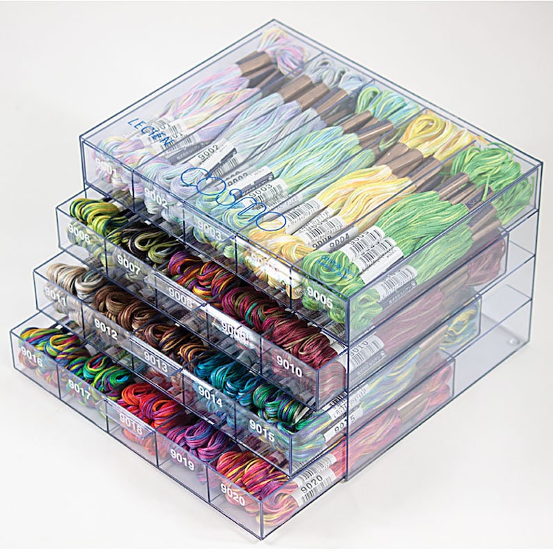 May include: A clear plastic storage box with multiple drawers, each containing colorful embroidery floss. The drawers are labeled with numbers, such as 9002, 9003, 9004, 9005, 9006, 9007, 9008, 9010, 9011, 9012, 9013, 9014, 9015, 9016, 9017, 9018, 9019, 9020.