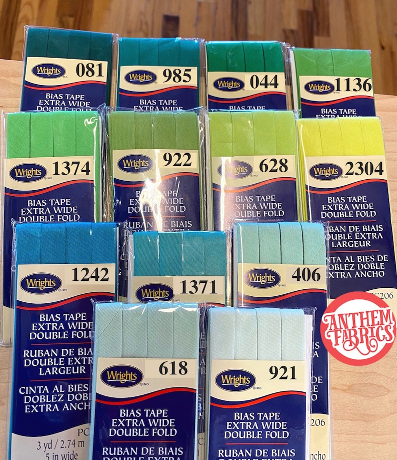 May include: A collection of 10 packages of bias tape in various colors, including green, blue, and yellow. Each package features the Wrights brand name and the text "Bias Tape Extra Wide Double Fold".