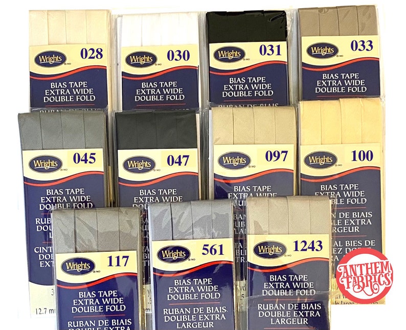 May include: A collection of bias tape in various colors, including beige, white, black, and gray. The tape is labeled "Wrights" and has the text "Bias Tape Extra Wide Double Fold" printed on it. The tape is available in different widths, including 12.7 mm.