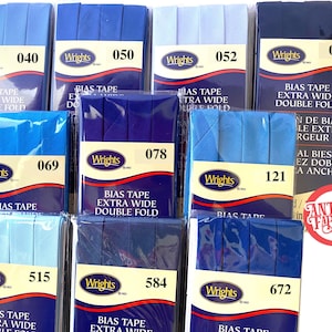 May include: Assortment of blue and light blue bias tape in various widths. The tape is packaged in clear plastic with a white label that reads "Wrights" and a number. The labels also include the text "Bias Tape Extra Wide Double Fold".
