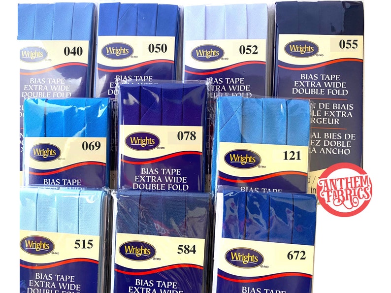 May include: Assortment of blue and light blue bias tape in various widths. The tape is packaged in clear plastic with a white label that reads "Wrights" and a number. The labels also include the text "Bias Tape Extra Wide Double Fold".