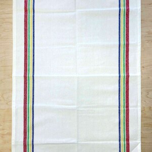 May include: White kitchen towel with red, green, yellow, and blue stripes along the sides.