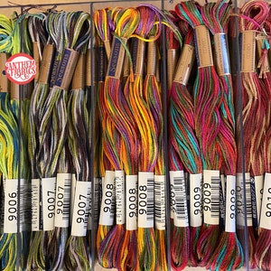 May include: A close-up of ten spools of embroidery floss, each with a different color combination. The spools are labeled with the numbers 9006, 9007, 9008, 9009, and 9010. The spools are arranged in a row, with the numbers increasing from left to right.