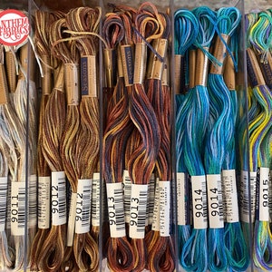 May include: A close-up of ten spools of embroidery floss, each with a different color combination. The spools are labeled with the numbers 9011, 9012, 9013, 9014, and 9015. The floss is arranged in rows of two, with the spools in each row alternating colors.