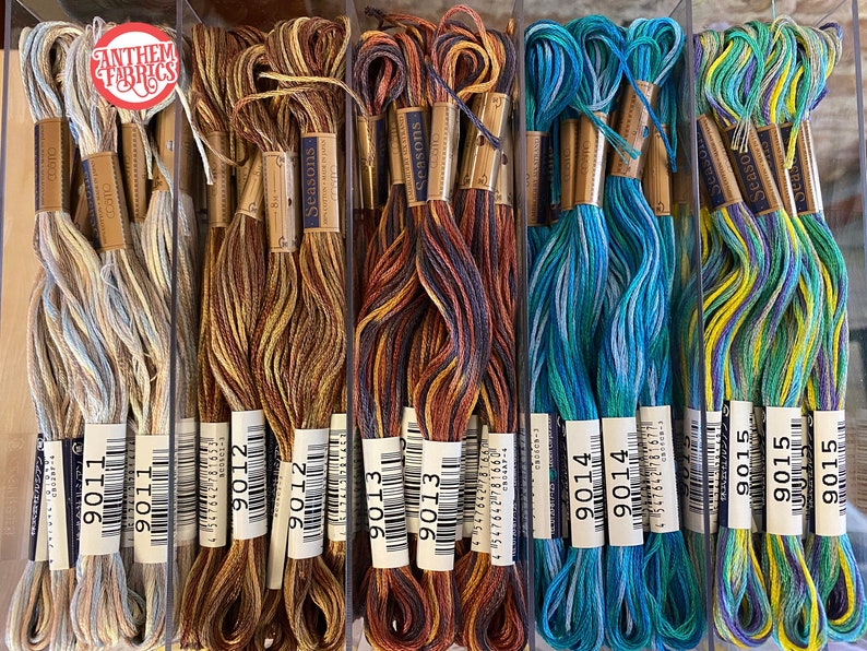 May include: A close-up of ten spools of embroidery floss, each with a different color combination. The spools are labeled with the numbers 9011, 9012, 9013, 9014, and 9015. The floss is arranged in rows of two, with the spools in each row alternating colors.