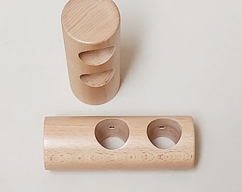 Könnte beinhalten: Zwei Holzhalter zum Aufbewahren von Gegenständen. Der größere Halter hat zwei runde Öffnungen und der kleinere Halter hat drei runde Öffnungen.