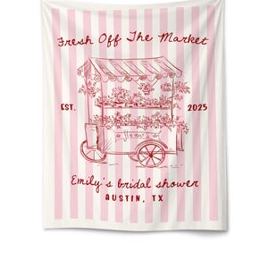 May include: A white and pink striped tapestry with a red sketch of a flower cart. The cart is filled with flowers and the text reads "Fresh Off The Market" and "Emily's bridal shower Austin, TX".