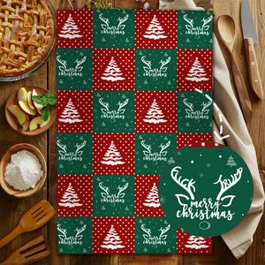 May include: A Christmas-themed kitchen towel with a repeating pattern of red polka dots, green squares, white Christmas trees, and the text "Merry Christmas" with a reindeer design. The towel is rectangular.
