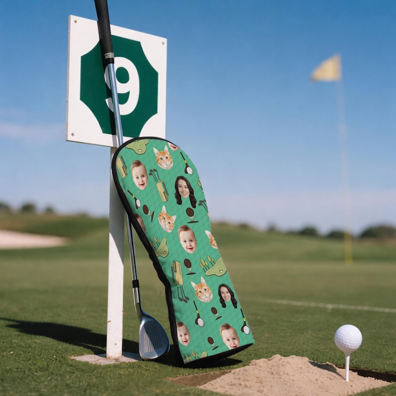 Może przedstawiać: Zielona osłona na gł&oacute;wkę kija golfowego z wzorem twarzy i kocich gł&oacute;w, kij&oacute;w golfowych i piłek golfowych. Osłona opiera się o biały słupek z zielonym znakiem z numerem 9. Widoczny jest r&oacute;wnież kij golfowy i piłka golfowa na tee.