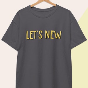 May include: A charcoal gray t-shirt with the text "LET'S NEW" in yellow.