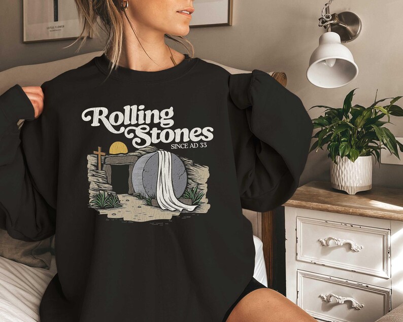 May include: Black sweatshirt with a graphic of a stone tomb with a cross and the text "Rolling Stones Since AD 33".
