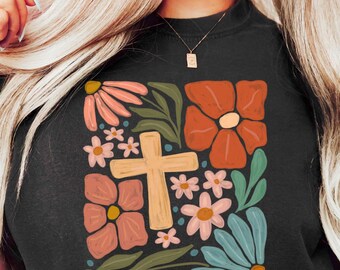 May include: Black t-shirt with a floral design featuring a cross in the center. The text "loved beyond measure" is printed below the design.