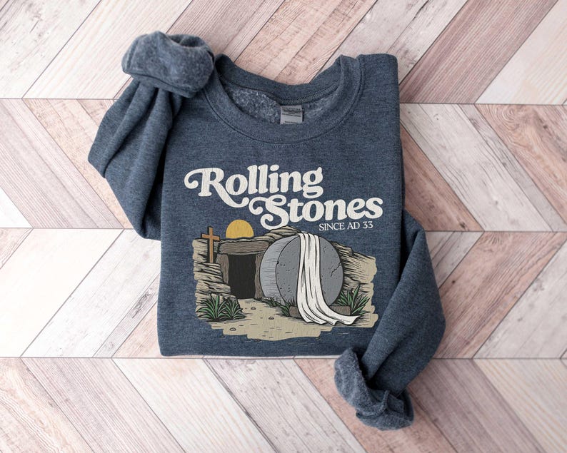 May include: A dark blue sweatshirt with a graphic of a stone tomb with a rolling stone and the text "Rolling Stones Since AD 33".
