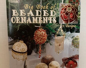 May include: A book titled "Big Book of Beaded Ornaments" with a red and gold beaded ornament on the cover. The book features 71 designs and shows a variety of beaded ornaments, including a star, a snowflake, and a bell.