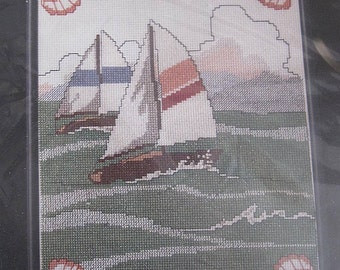 May include: Cross stitch pattern featuring three sailboats on a green and blue ocean with a border of red seashells. The pattern is titled "Sailboats 60393".