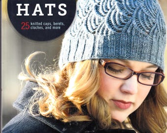 Könnte beinhalten: Ein Buchcover mit einer Frau, die einen blauen Strickhut mit einem strukturierten Design trägt. Der Buchtitel lautet "Weekend Hats" mit dem Untertitel "25 Strickmützen, Baskenmützen, Glockenhüte und mehr". Die Autorinnen sind Cecily Glowik Macdonald und Melissa Labarre.