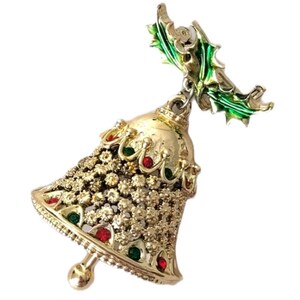 May include: Gold-toned Christmas bell brooch with red and green jewel accents. The bell is adorned with intricate floral detailing and topped with a green holly leaf design. A festive accessory for the holiday season.