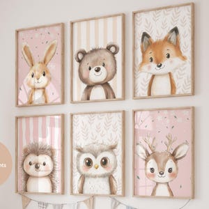 May include: Six framed nursery art prints featuring cute woodland animals: a bunny, bear, fox, hedgehog, owl, and deer. Each print has a pink background with various patterns and is encased in a wooden frame. The artwork is designed for a child's room.