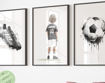 Puede incluir: Tres ilustraciones de acuarela en blanco y negro con temática de fútbol. La primera imagen muestra una bota de fútbol, la segunda imagen muestra a un niño pequeño con una camiseta de fútbol con el nombre "HUDSON" y el número "10" en la espalda, y la tercera imagen muestra un balón de fútbol.