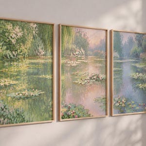 Könnte beinhalten: Ein Set aus drei vertikalen Wandbildern in hellen Holzrahmen, die jeweils eine impressionistische Landschaft eines Teichs mit Seerosen, üppigem grünem Laub sowie sanften rosa und blauen Reflexionen auf der Wasseroberfläche zeigen.