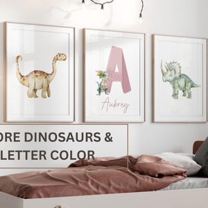 Pu&ograve; includere: Tre stampe ad acquerello incorniciate con dinosauri e lettere. La prima stampa mostra un dinosauro marrone. La seconda stampa mostra una lettera A rosa con un dinosauro verde. La terza stampa mostra un dinosauro verde. Il testo "Aubrey" &egrave; scritto sotto la lettera A. Il testo "MORE DINOSAURS & LETTER COLOR" &egrave; scritto sotto le stampe.