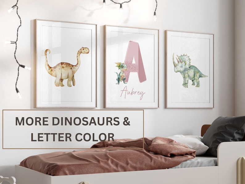 Pu&ograve; includere: Tre stampe ad acquerello incorniciate con dinosauri e lettere. La prima stampa mostra un dinosauro marrone. La seconda stampa mostra una lettera A rosa con un dinosauro verde. La terza stampa mostra un dinosauro verde. Il testo "Aubrey" &egrave; scritto sotto la lettera A. Il testo "MORE DINOSAURS & LETTER COLOR" &egrave; scritto sotto le stampe.