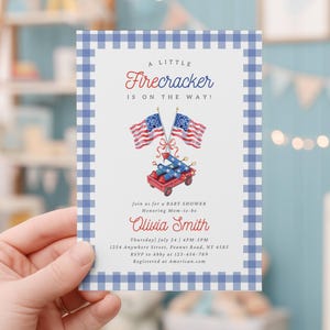 May include: A baby shower invitation with a blue gingham border. The invitation features the text "A Little Firecracker is on the Way!" along with illustrations of American flags and a red wagon. The name "Olivia Smith" is also displayed.