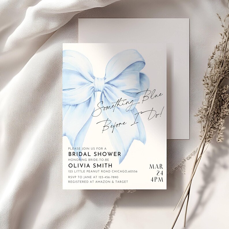 May include: A blue watercolor bow with the text "Something Blue Before I Do!" on a white background. The text "Please join us for a Bridal Shower honoring bride-to-be Olivia Smith 123 Little Peanut Road Chicago, 60556 RSVP to Jane at 123-456-7890 Registered at Amazon & Target Mar 24 4PM" is also on the card.