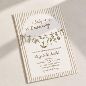 Può includere: Un biglietto d'invito rettangolare per baby shower con strisce verticali beige. Il testo recita a baby is brewing, join us for a baby shower in honor of Elizabeth Smith, Saturday September 10, 2pm-7pm, 233 Zombie Village, Blood St, RSVP to Jane 555.2345.345, Registered at Amazon.