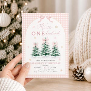 Puede incluir: Una tarjeta de invitación de cumpleaños rectangular con un borde de cuadros vichy rosa claro y blanco. El centro muestra un diseño arqueado con un lazo rosa, tres pinos verdes con lazos rosas y copos de nieve dorados. Texto: Winter ONEderland, Carmilla's 1st Birthday, Saturday September 12, 2pm-7pm, Anywhere City, NY 1256, Rsvp to Olivia at 123.456.7890.