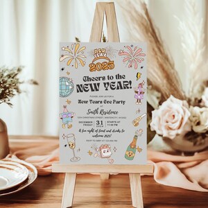 May include: A New Year's Eve party invitation on a small wooden easel. The invitation features the text "Cheers to the NEW YEAR!" with the year 2025, fireworks, and other festive illustrations. The invitation includes the date, time, and location.