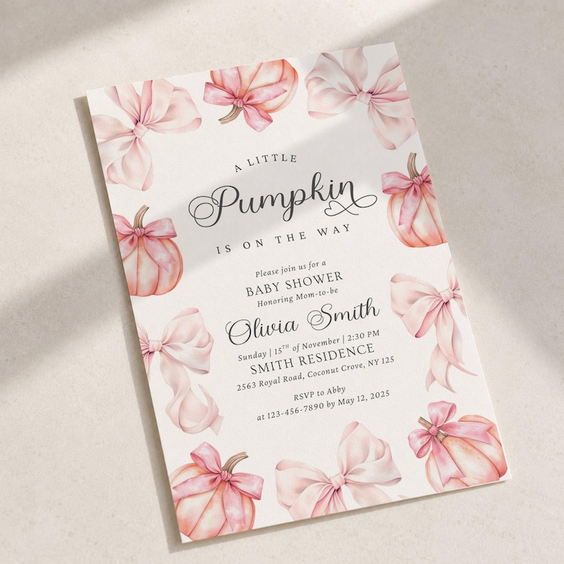 May include: A rectangular baby shower invitation card featuring watercolor illustrations of light pink pumpkins and bows. The text reads: A little Pumpkin is on the way, Please join us for a BABY SHOWER Honoring Mom-to-be Olivia Smith, Sunday 15th of November, 2:30 PM, SMITH RESIDENCE, 2563 Royal Road, Coconut Grove, NY 125, RSVP to Abby at 123-456-7890 by May 12, 2025.